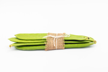 Flat Long Green Vegetable Runner Beans Known As Jhar Sim, Falia, Keralan, Sem Ki Phali, Surti Papdi, Guar Ki Fali, Gawar Isolated On White Background. Used To Cook Curry Bhaji Sabji Or Hari Sabzi - obrazy, fototapety, plakaty