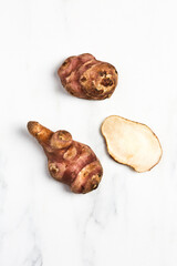 Overhead view of Jerusalem Artichokes on white marble