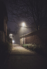 Fototapeta na wymiar Night view of passage in the fog, Kazimierz district of Krakow, former Jewish city