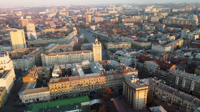 Sunny city aerial flight above autumn Podil district, downtown city streets rooftop in Kharkiv, Ukraine