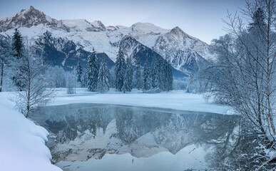 Reflet du Massif du Mont-Blanc sur un lac gelé en hiver 