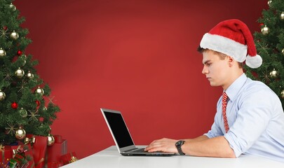 Young happy man having video call over laptop while celebrating Christmas alone at home.