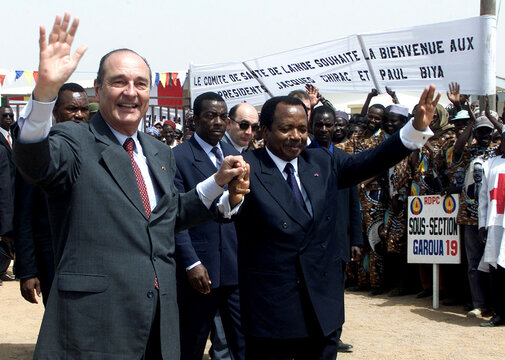 French President Jacques Chirac (L) and Cameroon President Paul Biya (R) hold hands as they arrive a..