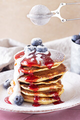 pancakes with jam, sour cream and blueberries sprinkled with powdered sugar. Pancakes for breakfast...