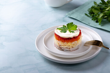 Traditional russian salad with herring and vegetables on a green background