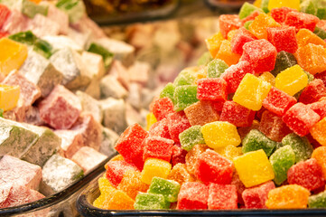 Assorted colorful Turkish delights on glass cake stand.