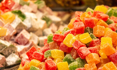 Assorted colorful Turkish delights on glass cake stand.