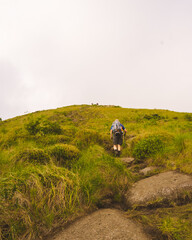 Obraz premium person hiking to the top of the mountain