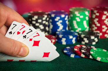 Poker cards with four of a kind or quads combination. Close up of gambler hand takes playing cards in poker club