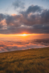 sun going down with a bright orange light casting clouds