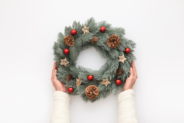 Christmas wreath in female hands. Top view.