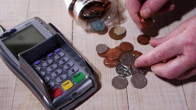 Counting cash in coins next to payment card reader