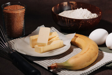 Ingredients for cooking banana bread on brown background
