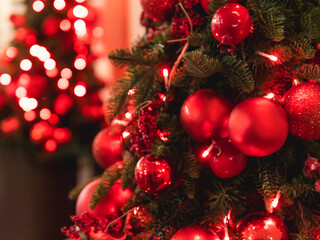 Christmas tree with red decorations. Fir tree decorated with light bulbs, balls and berries for New Year celebration.