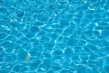 Fototapeta na wymiar Closeup surface of blue clear water with small ripple waves in swimming pool