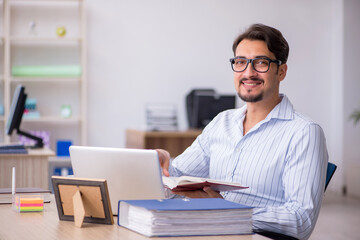 Obraz premium Young male employee student sitting in the office