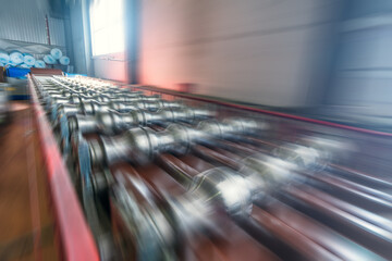 Conveyor belt or production line with blurred motion effect in metalwork manufacturing factory.