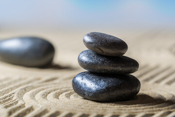 Obraz na płótnie Canvas Zen garden with stacked stones on sand.
