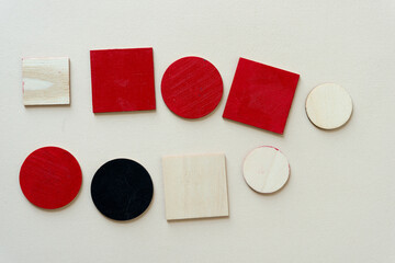 wooden shapes painted red or black on paper