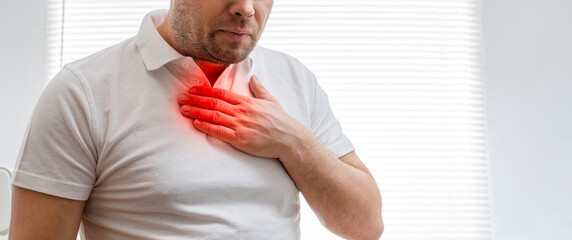 The young man is suffering from heartburn. Disease of the gastrointestinal tract. Sore throat.