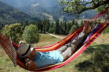 Obraz na płótnie Canvas Man resting in hammock outdoors on sunny day