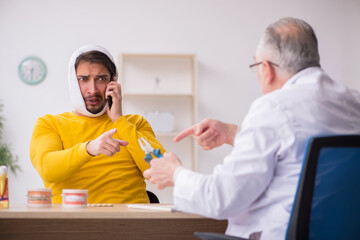 Young man visiting experienced male dentist