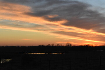 Sunset Over a Farm Field with a Lake