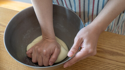 手作りパン。生地をねる女性の手。