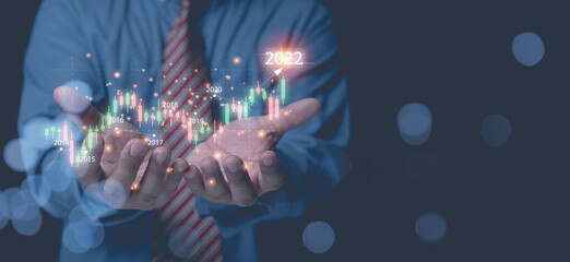 Businessman holding horizontal graph for analysis share, currency, forex, for year 2022 growth business to the future. Analysts trading share strategy analyzing from diagram graph for investment.