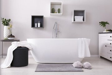 Stylish bathroom interior with modern white tub