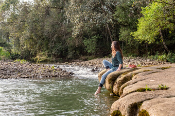 Woman sitting on a rock and relaxing in nature