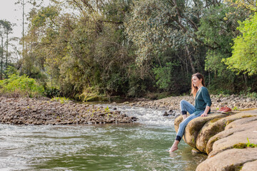 Woman sitting on a rock and relaxing in nature