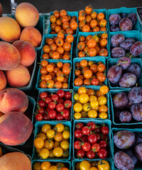 Looking down on blue crates of fresh fruit lined up on a table at a Farmers Market in Oregon.