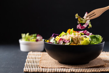 Fresh organic vegetables salad with quinoa seed in bowl on black background, Healthy Vegan food