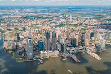 Obraz na płótnie Canvas Aerial panoramic city view of New Jersey City financial Downtown skyscrapers. Bird's eye view from helicopter. Jersey city is an important transportation center for the Port of New York and New Jersey