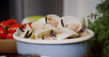 Fototapeta na wymiar Bowl with fresh mussels, process of mediterranean dish preparation at home. Fresh Mollusks Cooking Seafood.