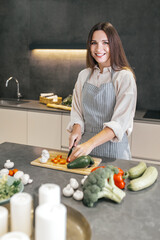 Long-haired young housewife cooking in the kitchen