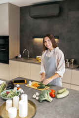 Long-haired young housewife cooking in the kitchen