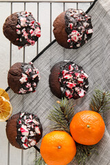 Grid with tasty candy cane cookies and tangerines on white background