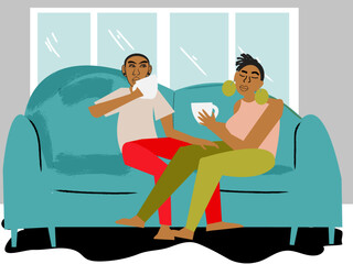 Gay couple having coffee on the couch in front of a window