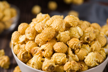 close up of popcorn in a bow  on wood background
