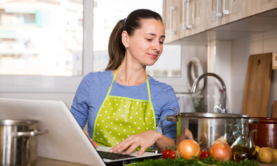 Young woman cooking recipe from the Internet. High quality photo