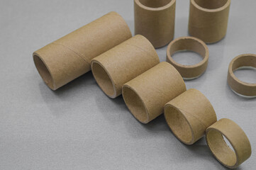 Cardboard spools for winding. Reels made of cardboard. Background of cardboard bobbins. Selective focus