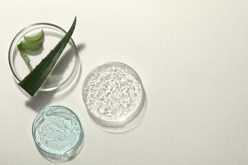 Flat lay composition with cosmetic gel and aloe on white background, space for text