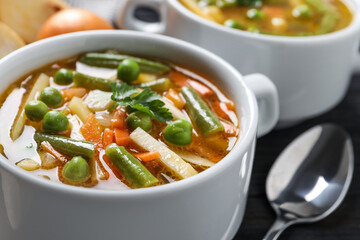 Bowl of tasty turnip soup and spoon on table, closeup