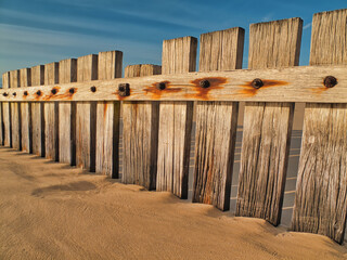 Weather beaten wooden fence on sandy beach