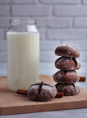homemade round gingerbread with cinnamon in powdered sugar on a board with milk