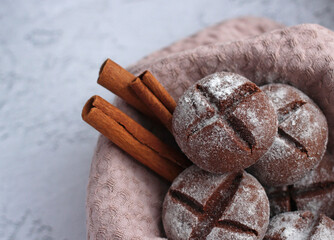 round homemade gingerbread with cinnamon and powdered sugar on a gray background