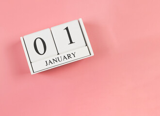 wooden calendar 01 January on pink background. First day of the year.
