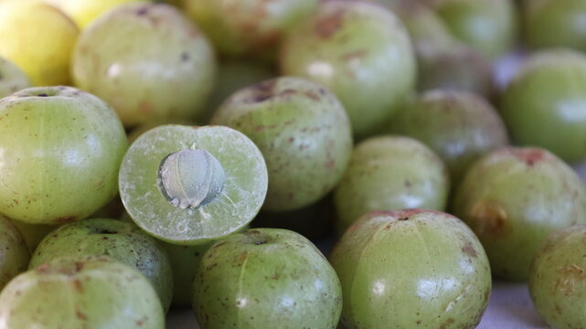 Fresh Indian gooseberry fruit. Close up Slice Amla or Amalaka (Phyllanthus emblica L.) is a round green forest fruit with natural mottled marks. selective focus